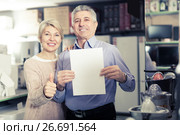 Nice mature couple buying on credit agreement for home appliances. Стоковое фото, фотограф Яков Филимонов / Фотобанк Лори