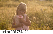 Little girl with a flower on nature. Стоковое видео, видеограф Илья Шаматура / Фотобанк Лори