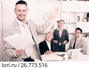 Happy entrepreneur with papers standing in office. Стоковое фото, фотограф Яков Филимонов / Фотобанк Лори