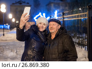 Взрослые мужчина и женщина делают селфи на фоне огней ночного города. Стоковое фото, фотограф Игорь Низов / Фотобанк Лори