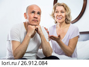 Mature girlfriend consoling grieving man sitting apart. Стоковое фото, фотограф Яков Филимонов / Фотобанк Лори