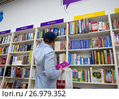 Мужчина выбирает книги в книжном магазине (2017 год). Редакционное фото, фотограф Вячеслав Палес / Фотобанк Лори