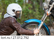 Девушка в мотоциклетном шлеме смотрит на фару мотоцикла, крупный план. Стоковое фото, фотограф Кекяляйнен Андрей / Фотобанк Лори