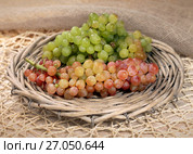 Juicy fresh red and white grapes in a wattled basket. Стоковое фото, фотограф ElenArt / Фотобанк Лори