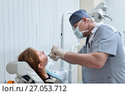 Male Dentist remove tooth of woman patient using forceps. Health care dentistry medicine concept. Стоковое фото, фотограф Сергей Дорошенко / Фотобанк Лори