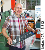 Smiling senior man doing vehicle numbers on machine. Стоковое фото, фотограф Яков Филимонов / Фотобанк Лори