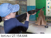 Мальчик стреляет из ружья в стрелковом тире. Стоковое фото, фотограф Юлия Юриева / Фотобанк Лори