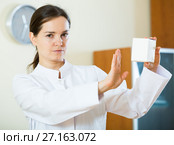 Serious female physician warning of faulty drugs. Стоковое фото, фотограф Яков Филимонов / Фотобанк Лори