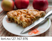 Кусочек шарлотки с яблоками и ножик на фоне красных яблок. Стоковое фото, фотограф Игорь Низов / Фотобанк Лори