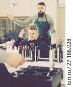 outraged man client expressing dissatisfaction about his haircut at hair salon. Стоковое фото, фотограф Яков Филимонов / Фотобанк Лори