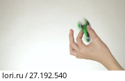 Hands of a teenage girl spin a green fidget spinner on white background stock footage video. Стоковое видео, видеограф Юлия Машкова / Фотобанк Лори
