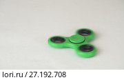 Green fidget spinner turns and stops on white background stock footage video. Стоковое видео, видеограф Юлия Машкова / Фотобанк Лори