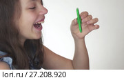 Beautiful cheerful teen girl playing with green fidget spinner on white background stock footage video. Стоковое видео, видеограф Юлия Машкова / Фотобанк Лори