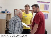 Пожилой мужчина задаёт вопрос врачу и тренеру центра доктора Бубновского (2017 год). Редакционное фото, фотограф Дмитрий Неумоин / Фотобанк Лори
