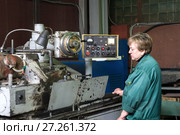 A woman works on an internal grinding machine. Stage of metal finishing of parts. (2017 год). Редакционное фото, фотограф Андрей Радченко / Фотобанк Лори
