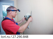 Male electrician connects the lamp on the wall. Стоковое фото, фотограф Наталья Давыдова / Фотобанк Лори