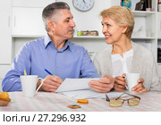 Mature married couple discuss contract and sign important documents. Стоковое фото, фотограф Яков Филимонов / Фотобанк Лори