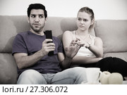 Couple on sofa quarreling because of TV remote. Стоковое фото, фотограф Яков Филимонов / Фотобанк Лори