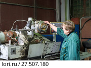 A woman works on an internal grinding machine. Stage of metal finishing of parts. (2017 год). Редакционное фото, фотограф Андрей Радченко / Фотобанк Лори
