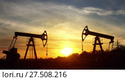 Working oil pumps silhouette against sunset. Стоковое видео, видеограф Михаил Коханчиков / Фотобанк Лори