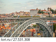 View of the historic city of Porto with the arch Dom Luis I bridge and a metro tram. At dawn. Стоковое фото, фотограф Сергей Цепек / Фотобанк Лори