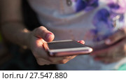 A girl looks at the screen of a mobile phone. Стоковое видео, видеограф Roman Larchikov / Фотобанк Лори