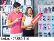 woman and man bayers choosing long rubber phallus in the sex shop. Стоковое фото, фотограф Яков Филимонов / Фотобанк Лори