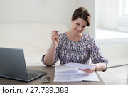 Woman working with documents looking at laptop. Стоковое фото, фотограф Володина Ольга / Фотобанк Лори
