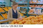 Woman buying fresh grapefruits at grocery store. Стоковое видео, видеограф Aleksey Popov / Фотобанк Лори