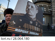 Мужчина держит портрет знаменитого военачальника, маршала Советского Союза Леонида Говорова во время демонстрации и митинга, посвященных столетию Советской Армии и Военно-Морского флота в городе Москве, Россия, 23 февраля 2018. Редакционное фото, фотограф Николай Винокуров / Фотобанк Лори