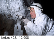 Cave explorer carefully examines the structure of the ice formations through a magnifying glass. Стоковое фото, фотограф Евгений Харитонов / Фотобанк Лори