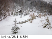 Wooden buildings and brook in Russian Orthodox Monastery at winter day among forest. Стоковое фото, фотограф Losevsky Pavel / Фотобанк Лори