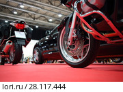 Black bikes for cortege, car are on red carpet in exhibition, close up. Стоковое фото, фотограф Losevsky Pavel / Фотобанк Лори