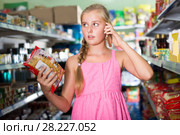 Customer girl is advised by phone what pasta she should buy. Стоковое фото, фотограф Яков Филимонов / Фотобанк Лори