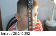 Child in an ophthalmic clinic. Checking visual acuity with a line of ski-like. Стоковое видео, видеограф Константин Мерцалов / Фотобанк Лори