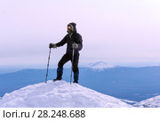 Climber in a windproof mask and glasses reached the snow top of the mountain. Стоковое фото, фотограф Евгений Харитонов / Фотобанк Лори
