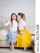 Two young girls are sitting on the couch. Стоковое фото, фотограф Типляшина Евгения / Фотобанк Лори