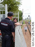 Полицейский разговаривает с нетрезвым гражданином на железнодорожной платформе (2016 год). Редакционное фото, фотограф Free Wind / Фотобанк Лори