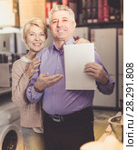 Pretty mature couple buying on credit agreement for home appliances. Стоковое фото, фотограф Яков Филимонов / Фотобанк Лори