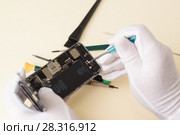 Руки мастера в белых перчатках с помощью отвертки разбирают смартфон для ремонта. Стоковое фото, фотограф Наталья Гармашева / Фотобанк Лори