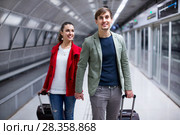 Portrait of couple with wheeled trollers at subway platform. Стоковое фото, фотограф Яков Филимонов / Фотобанк Лори