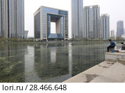 TIANJIN, CHINA - APRIL 8, 2017. A modern building along the Haihe River in Tianjin, China. Редакционное фото, фотограф Яна Королёва / Фотобанк Лори