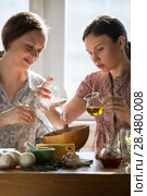 Women cooking pizza at home. Two women kneading dough. Стоковое фото, фотограф Kirill Kedrinskiy / Ingram Publishing / Фотобанк Лори