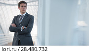 Cheerful serious young businessman standing in urban surrounding with arms crossed. Стоковое фото, фотограф Kirill Kedrinskiy / Ingram Publishing / Фотобанк Лори