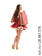 Christmas, x-mas, winter, happiness concept - smiling woman in Santa Claus dress with shopping bags. Стоковое фото, агентство Ingram Publishing / Фотобанк Лори