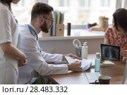 Confident practitioner consulting woman in hospital. Explaining results of chest x-ray scan. Стоковое фото, агентство Ingram Publishing / Фотобанк Лори