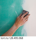 Plastering man hand sanding the plaste in drywall seam plasterboard. Стоковое фото, фотограф Tono Balaguer / Ingram Publishing / Фотобанк Лори