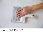 Plastering man hand with plaste and plaster spatula trowel in wall. Стоковое фото, фотограф Tono Balaguer / Ingram Publishing / Фотобанк Лори