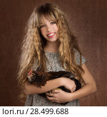 Children fashion farmer girl holding hen in retro vintage background. Стоковое фото, фотограф Tono Balaguer / Ingram Publishing / Фотобанк Лори