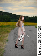 Alone young woman stands with violin by country road. Стоковое фото, фотограф Olena Mykhaylova / Ingram Publishing / Фотобанк Лори